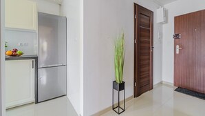 A modern kitchen with a stainless steel refrigerator, a fruit bowl, and a potted plant. - Apartment with Private Balcony (Warszawa 2)