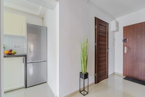 Eine moderne Küche mit einem Edelstahl-Kühlschrank, einer Obstschale und einem Blumentopf.