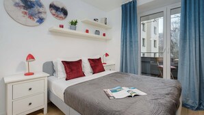 A bedroom with a bed, nightstands, a magazine, and a view through a window. - Beachfront Villa with Panoramic Sea Views (Warszawa 2)