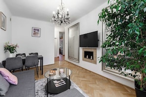 Ein modernes Wohnzimmer mit Kamin, Essbereich und großem Spiegel.