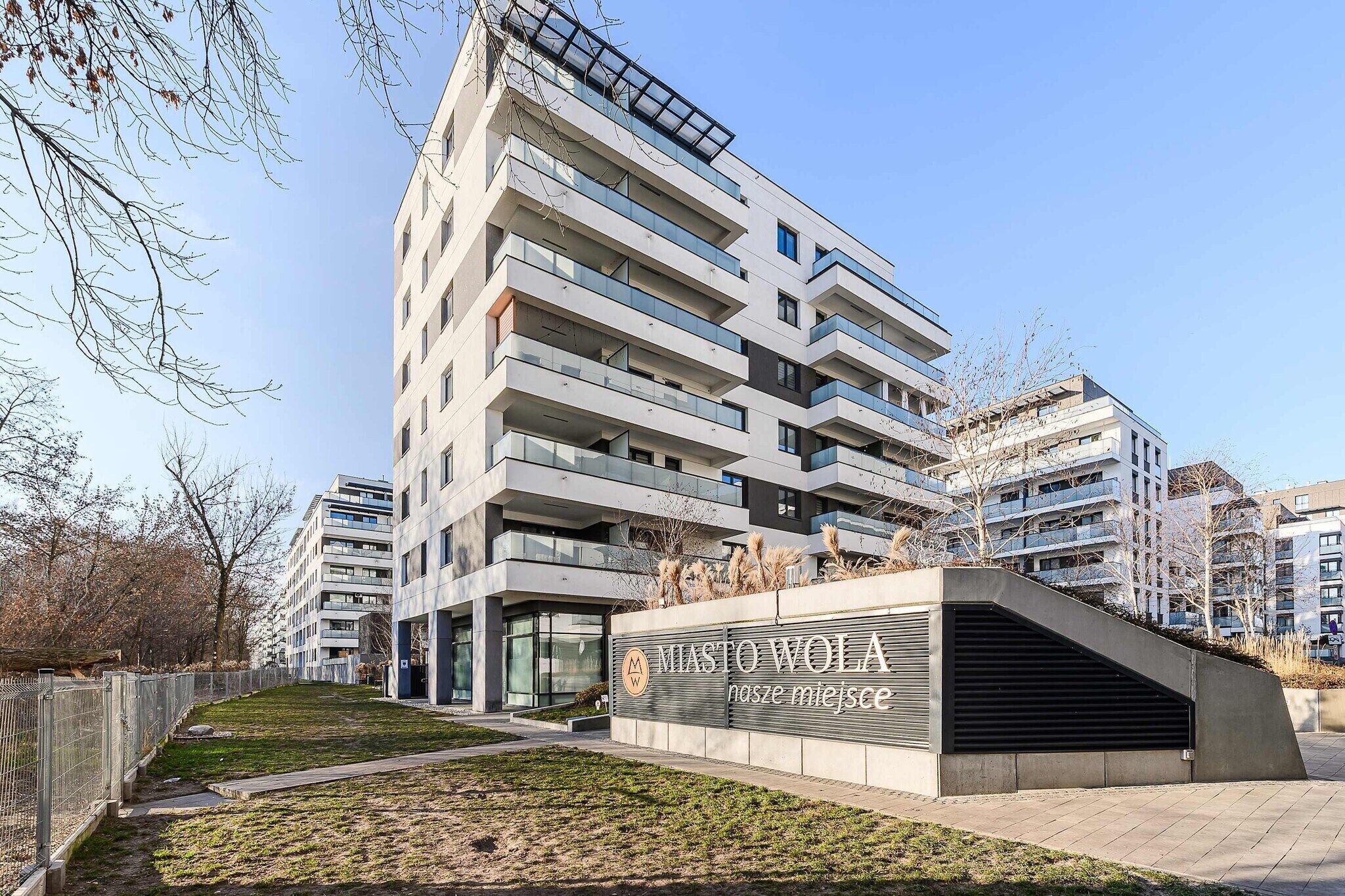 A multi-story residential building with a modern design, featuring balconies and large windows.