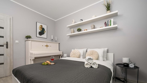 Ein modernes Schlafzimmer mit einem Bett, einem Nachttisch und einer weißen Kommode.
