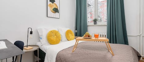 Escritorio, tabla de planchar con plancha, internet y ropa de cama