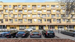 A multi-story yellow building with several parked cars in front. - Old Town Apartment for 4 (Warszawa)