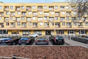 A multi-story yellow building with several parked cars in front. - Old Town Apartment for 4 (Warszawa)