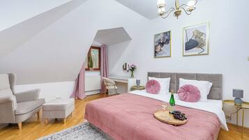 A bedroom with a bed, a chair, a desk, and a window.