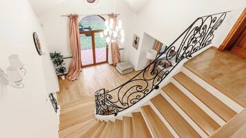 A wooden staircase with black metal railings leading to a landing.