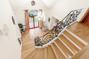 A wooden staircase with black metal railings leading to a landing.