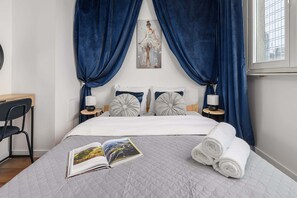 A neatly made bed with a quilted cover, two bedside lamps, and a painting above it. - Warsaw Flat on Pereca (Warszawa 2)