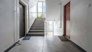 Ein Flur mit einer Treppe zu einer Tür, an der die Nummer 17 angebracht ist.