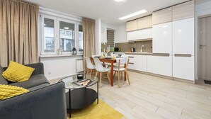 Ein modernes Wohnzimmer mit einer Couch, einem Couchtisch und einem Essbereich mit Stühlen.
