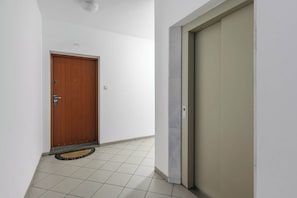 A hallway with a wooden door and a beige sliding door, both with simple handles. - Stylish Warsaw Apartment with Balocny (Warszawa 2)