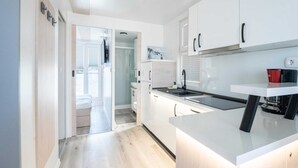 A modern kitchen with white cabinetry, a built-in oven, and a coffee machine. - Houseboat With Rooftop Whirlpool in Novigrad (Novigrad)