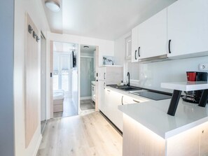 A modern kitchen with white cabinetry, a built-in oven, and a coffee machine. - Houseboat With Rooftop Whirlpool in Novigrad (Novigrad)