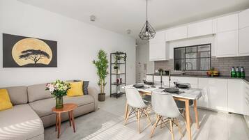 Un salon moderne avec un canapé, une table basse et un coin repas.