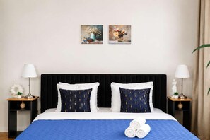 Ein Hotelzimmer mit einem großen Bett, zwei Nachttischen, zwei Lampen und zwei Wandbildern.