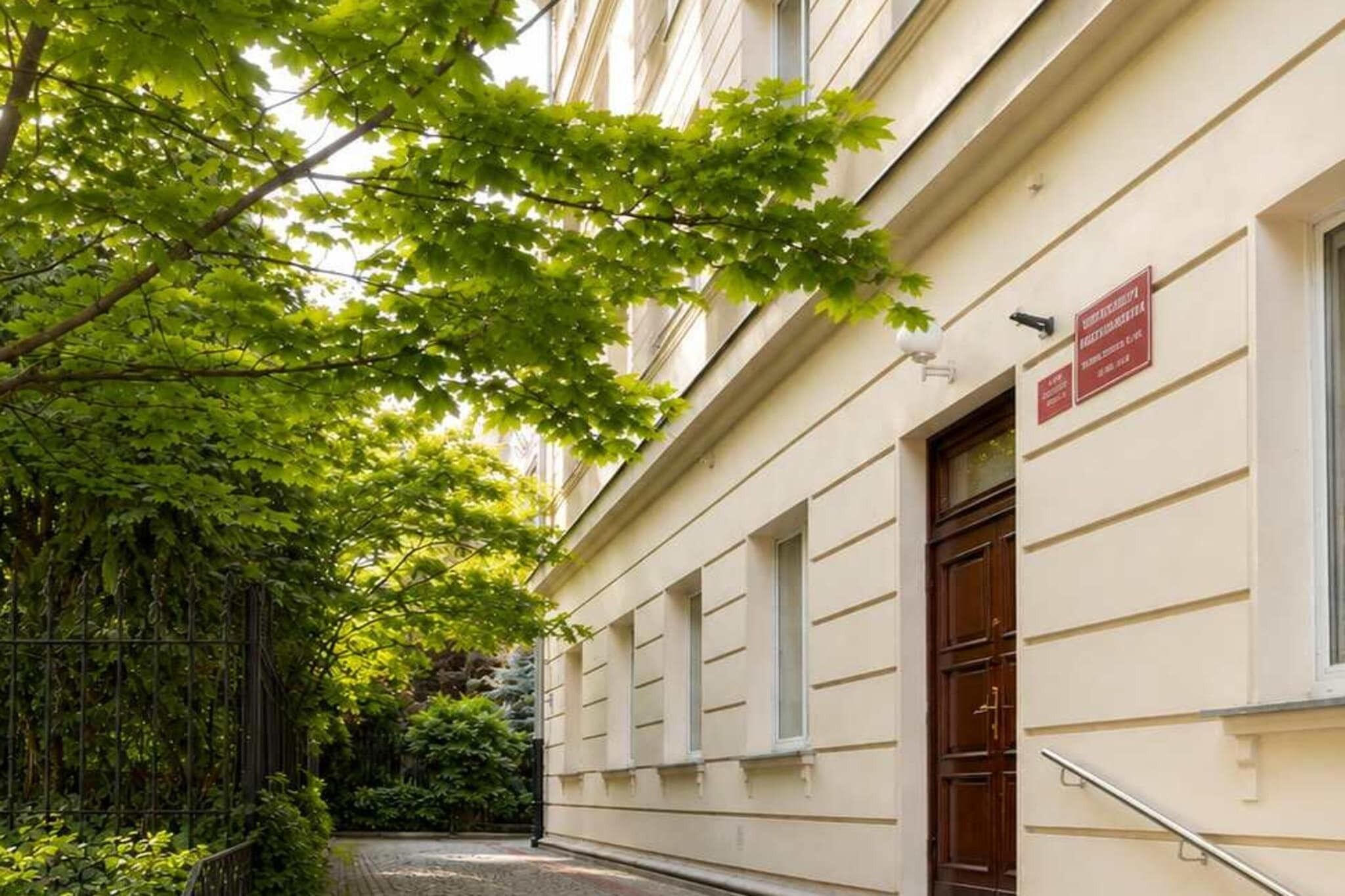 Un bâtiment de style architectural traditionnel, caractérisé par une entrée imposante avec une porte en bois et une enseigne placée au-dessus.