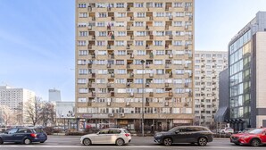 A multi-story residential building with numerous balconies and a ground-level commercial area. - House in Porspoder by Plage du Bourg Beach (Warszawa 2)