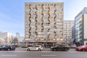 A multi-story residential building with numerous balconies and a ground-level commercial area. - House in Porspoder by Plage du Bourg Beach (Warszawa 2)