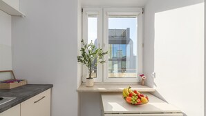 A compact kitchen with a window, a potted plant, and a fruit bowl on the counter. - House in Porspoder by Plage du Bourg Beach (Warszawa 2)