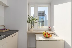 A compact kitchen with a window, a potted plant, and a fruit bowl on the counter. - House in Porspoder by Plage du Bourg Beach (Warszawa 2)