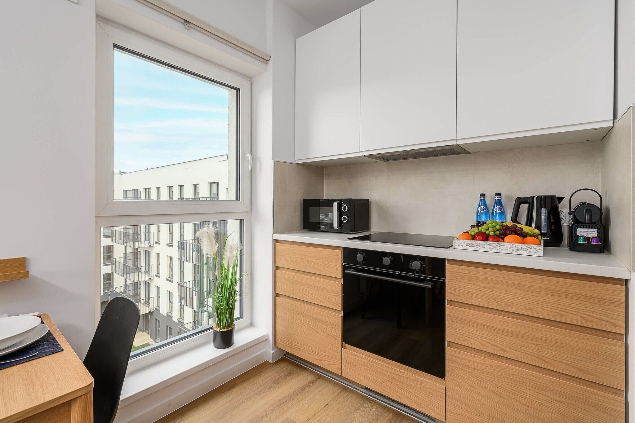 A modern kitchen with a built-in oven, microwave, and Bosch coffee maker.