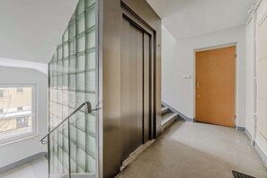 Ein Korridor mit Glastür, Holztür und Treppe.