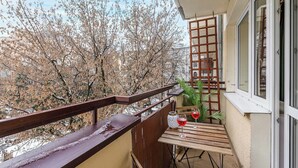 A balcony with a wooden table, two glasses of red wine, and a potted plant. - Waterfront House in Ploudalmézeau (Warszawa 2)
