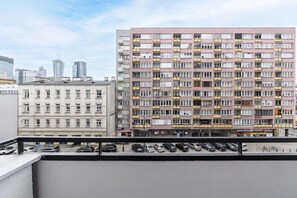 A multi-story residential building with balconies and a parking area in front. - City Apartment in Warsaw (Warszawa 2)