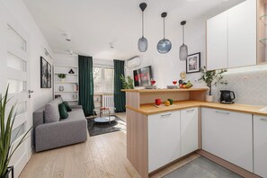 A modern apartment with a living room, kitchen, and dining area. - Modern Family Apartment with Play Area (Warszawa)