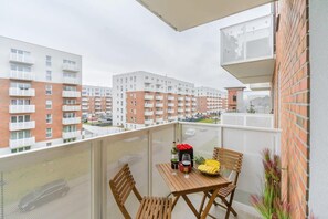 Ein Balkon mit Tisch, Stühlen und Blick auf Wohnhäuser.