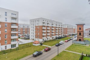 A multi-story residential building with balconies, a parking area, and a small brick structure. - Aesthetic Family Stay in Łódź City (Łódź)