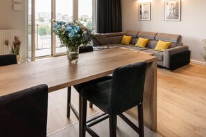 A modern living room with a sofa set, a dining table with chairs, and a vase of flowers. - Character house with Spa and seaview (Łódź)
