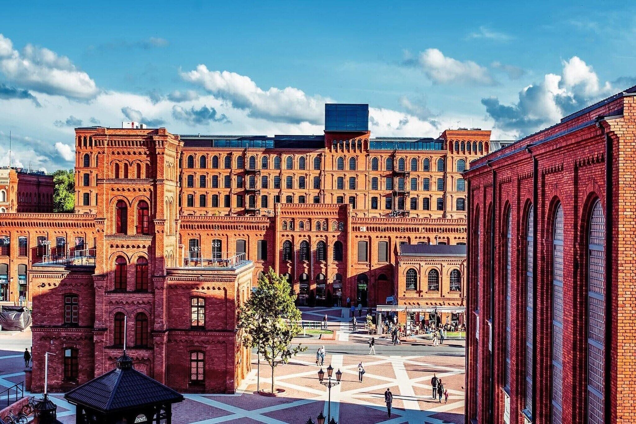 A large red brick building with multiple windows and a central courtyard.
