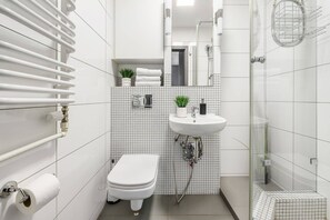 Ein modernes Badezimmer mit Toilette, Waschbecken und Dusche.
