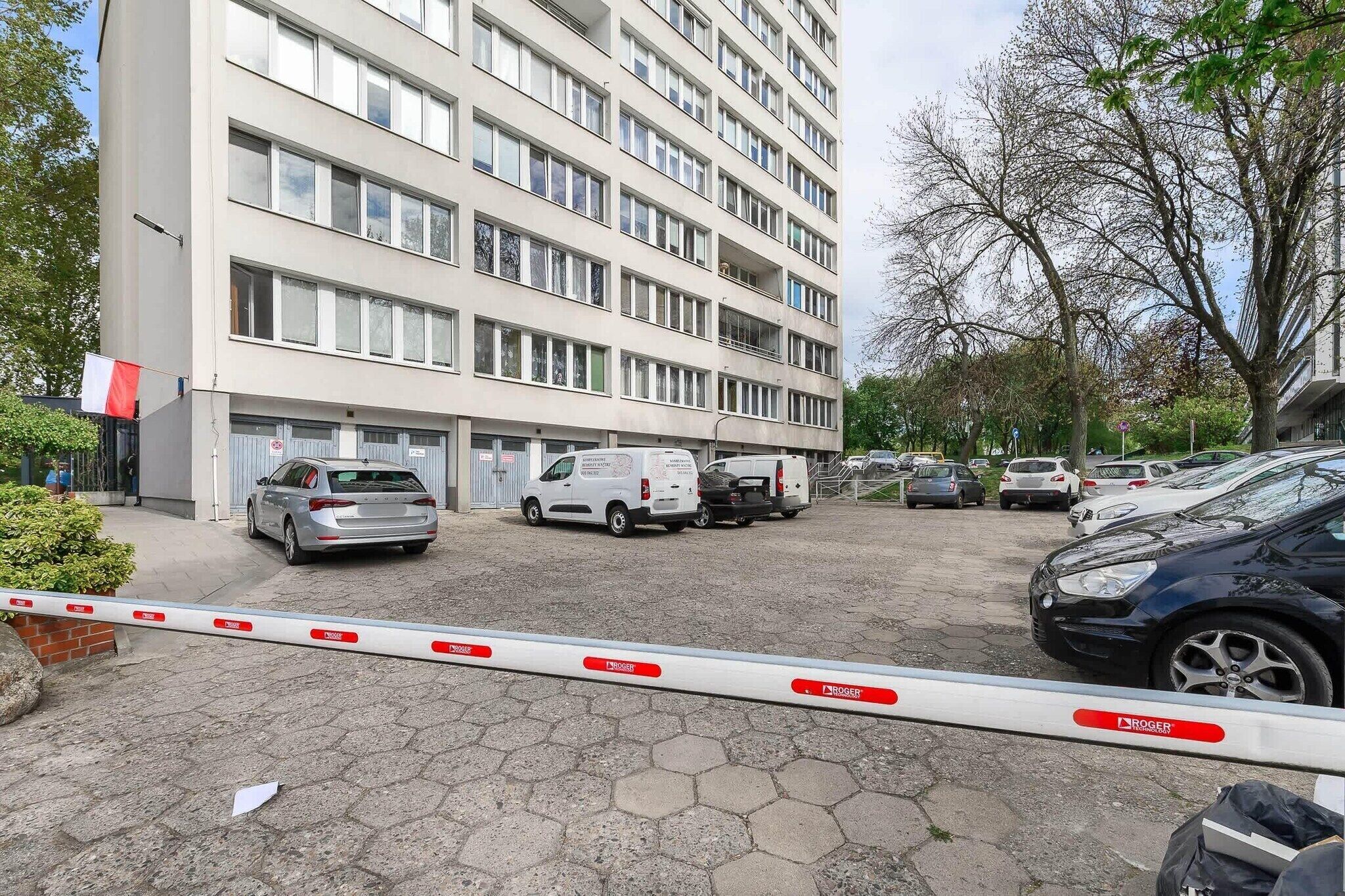 Un immeuble à plusieurs étages avec un espace de stationnement à l’avant.