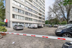 Ein mehrstöckiges Gebäude mit Parkplatz davor.