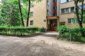 Ein gepflasterter Weg führt zu einem Gebäudeeingang, an dem ein Schild die Nummer 139 zeigt.