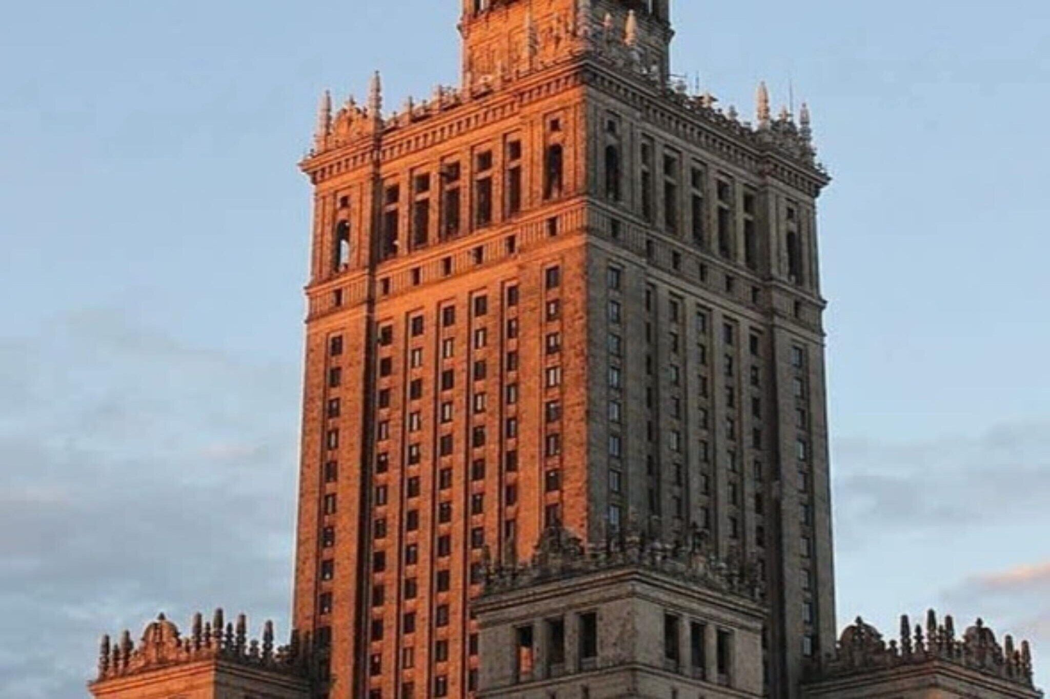 A tall, historic building with a central tower and multiple windows.