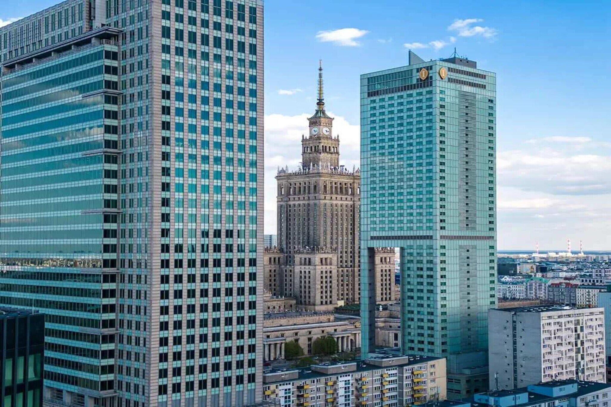 A cityscape with modern high-rise buildings and a historic tower.