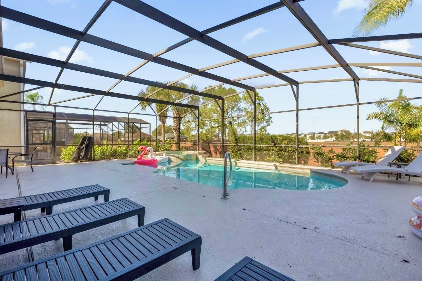 Une piscine extérieure avec des chaises longues et un espace salon abrité.