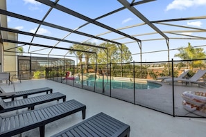 Un espacio al aire libre techado con piscina, sillas de descanso y una mesa.