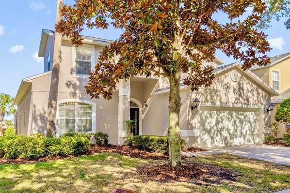 A two-story house with a covered driveway, a front porch, and a garage.