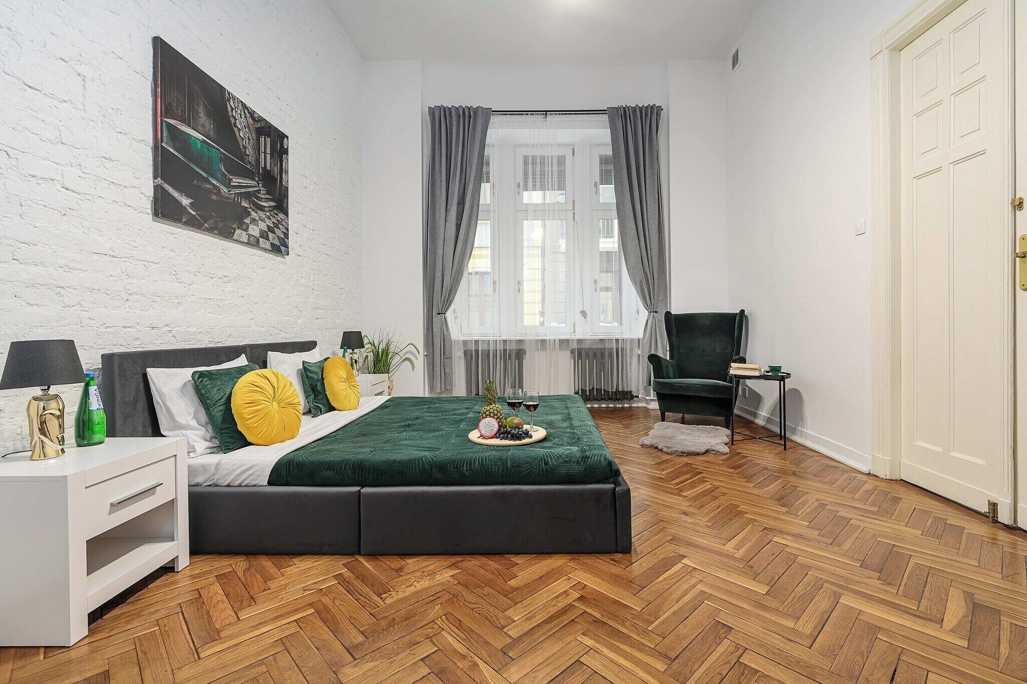 A modern bedroom with a bed, a side table, a chair, and a television.