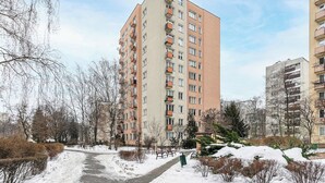 A multi-story residential building with balconies, a snow-covered path, and leafless trees. - Stay in Warsaw Center (Warszawa)
