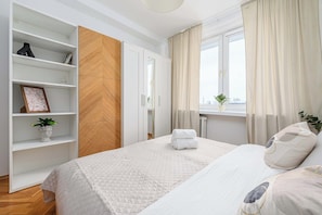 A hotel room with a bed, a wardrobe, a window with curtains, and a potted plant. - House in Plourin near Sandy Beaches (Warszawa 2)