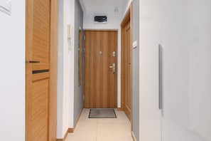 A narrow hallway with wooden doors and a tiled floor. - House in Plourin near Sandy Beaches (Warszawa 2)