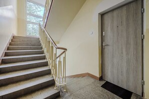 Eine Treppe mit Geländer führt zu einer Tür mit Holzvertäfelung.