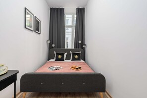 Ein Schlafzimmer mit einem Bett, einem Nachttisch und einem Fenster mit Vorhängen.