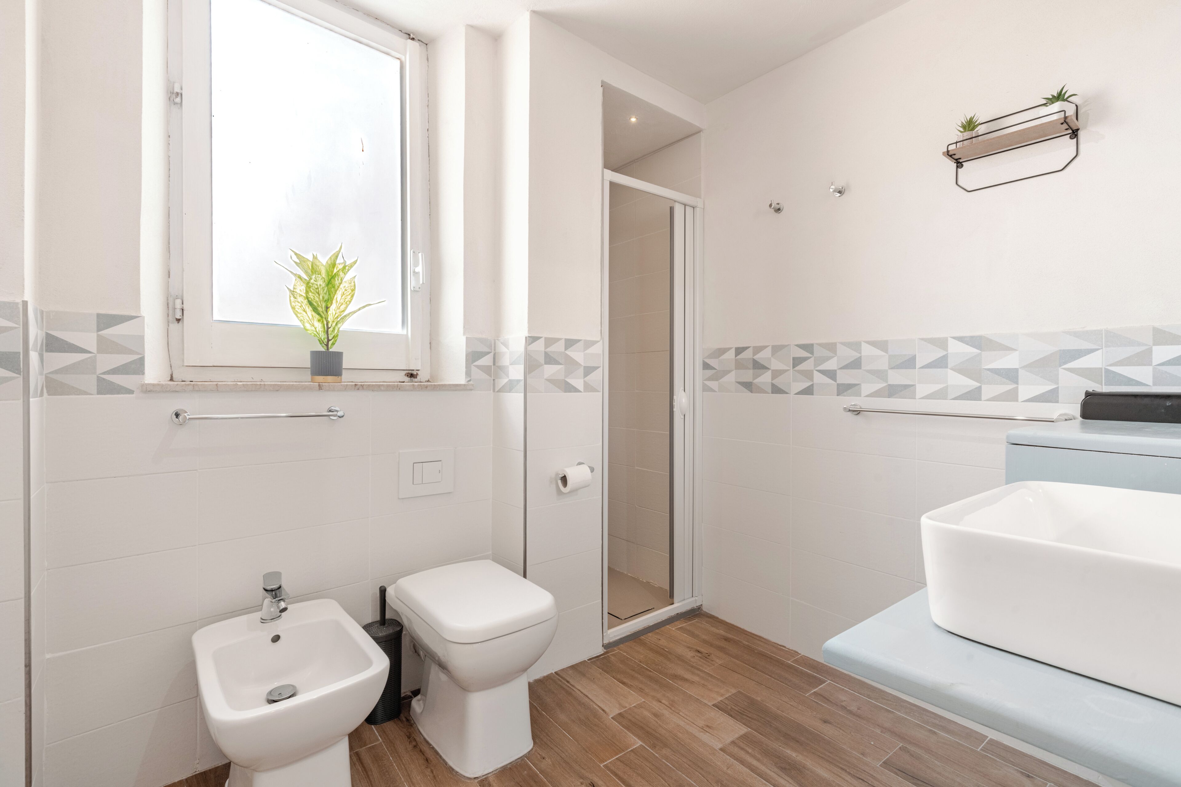 A modern bathroom with a bidet, toilet, and sink.